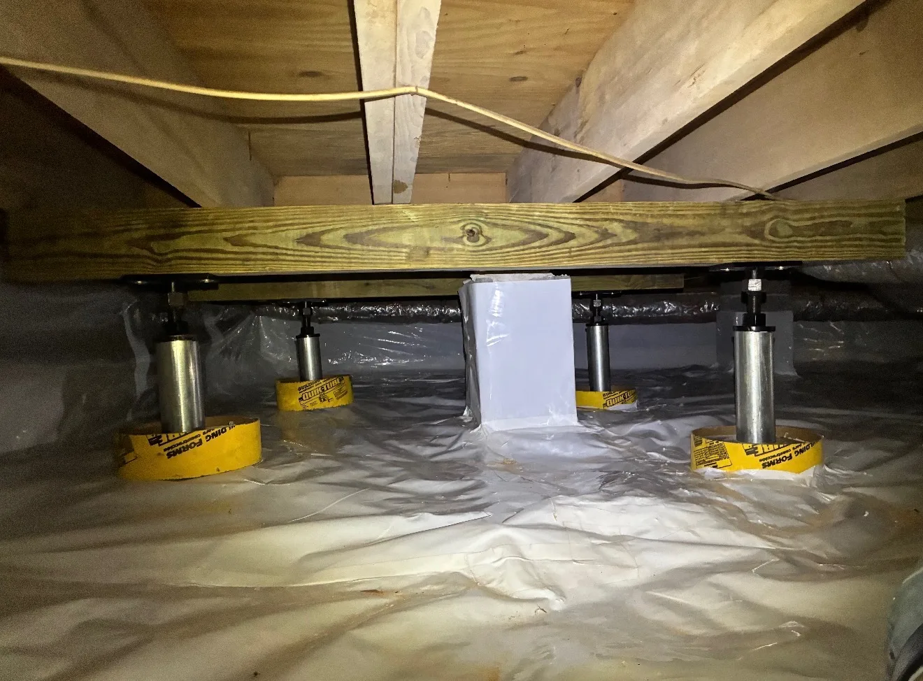 Steel support jacks under a crawlspace beam